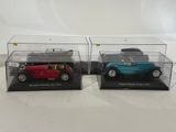 two model cars are in a clear display case on a white surface