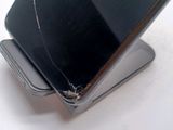 a broken cell phone sitting on top of a metal stand