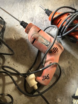 une perceuse et d'autres outils posés par terre dans un garage