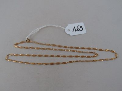 a close up of a gold chain with a tag on it
