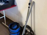a vacuum and a bucket on the floor next to a desk