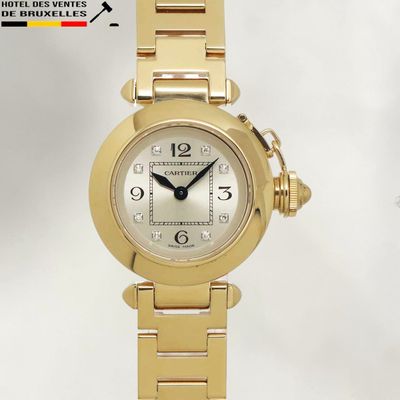 an image of a woman ' s wrist watch with a gold bracelet