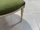 une chaise verte posée sur un sol carrelé dans une pièce