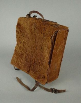 un petit sac marron posé sur une surface blanche