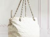 a white and black handbag sitting on top of a wooden table