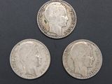 three silver coins with a profile of a man and a head of a woman