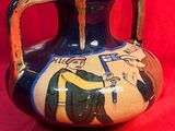 un vase orné d'une peinture sur fond rouge