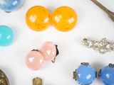 a lot of different types of jewelry on a white surface