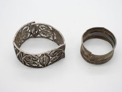 deux bracelets en argent et une bague en argent posés sur une surface blanche