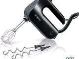 a black hand mixer with a wire handle and a whisk attachment