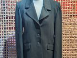 a suit on a mannequin stand in front of a woven wall