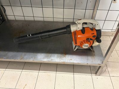 a blower sitting on a metal shelf in a bathroom