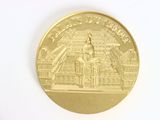 a gold coin with a picture of a building on it