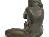 statue of a woman sitting on her back on a white surface