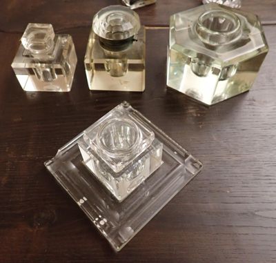 trois bougeoirs en verre posés côte à côte sur une table