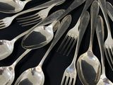 a lot of silver spoons and forks arranged in a circle