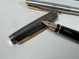 two fountain pens sitting next to each other on a table