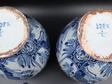 two blue and white vases with chinese writing on them
