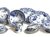 many blue and white plates and cups on the table