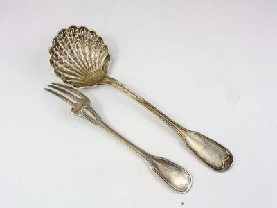silver plated serving utensils and spoons on a white surface