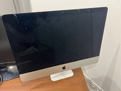 an apple desktop computer sitting on top of a wooden desk