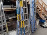 many ladders that are stacked up in a warehouse