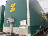 un grand camion vert avec un logo « z » jaune sur le côté