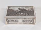 une vieille boîte en argent ornée d'un cerf, posée sur une table