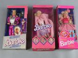 three barbie dolls are lined up in a row on a table