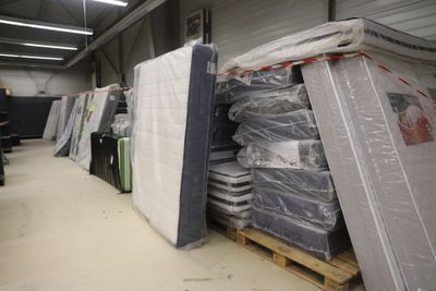 de nombreux matelas empilés sur des palettes dans un entrepôt