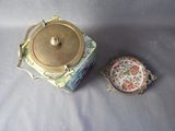 a small box with a lid sitting next to a small bowl