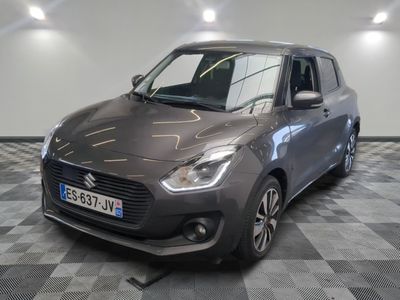 the small grey car is parked in a room with a checkered floor