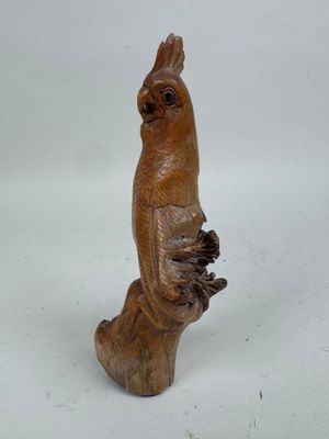 un oiseau en bois perché sur une souche d'arbre