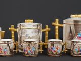 a group of porcelain tea pots and cups on a table