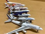 Plusieurs maquettes d'avions sont alignées en rang sur une table.