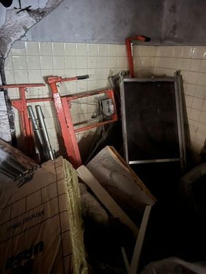 une photo d'un homme dans une pièce sale, entouré de cartons