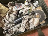 une valise pleine de déchets posée par terre à côté d'une poubelle