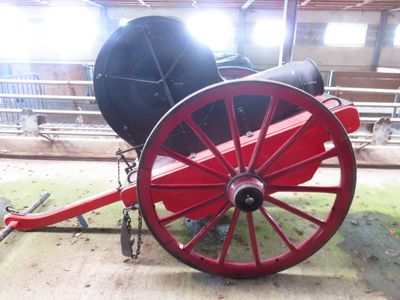 un chariot rouge avec une roue noire posée par terre
