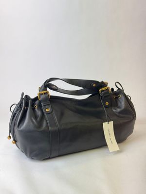 a black purse with a tag on it sitting on a white surface