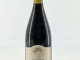 une bouteille de vin posée sur une table blanche