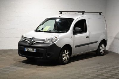 une camionnette blanche garée dans une pièce au sol en damier