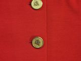 a close up of a red dress with buttons on it