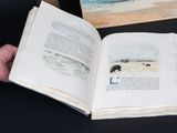 a person holding an open book with a picture on it