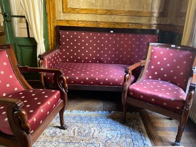 two chairs and a couch in a room with a rug