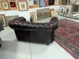 a couch and a chair in a room with pictures on the wall