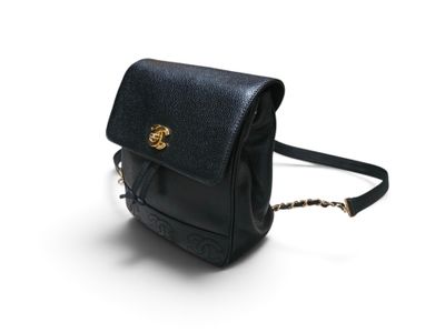 un sac à main noir muni d'une bandoulière en chaîne, sur fond blanc