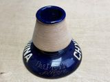 a blue vase with a brown base on a wooden table