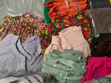 a pile of clothing that is sitting on a bed