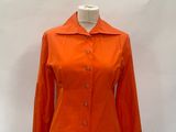 an orange jacket on a mannequin stand against a white backdrop