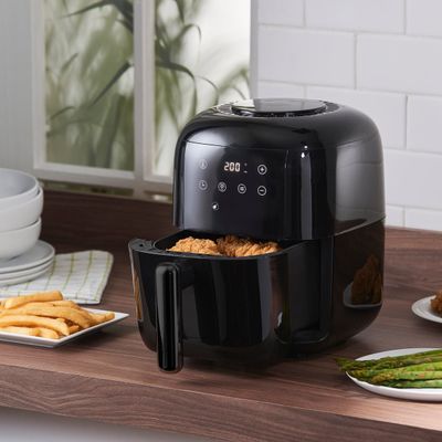 une friteuse à air chaud noire posée sur un plan de travail